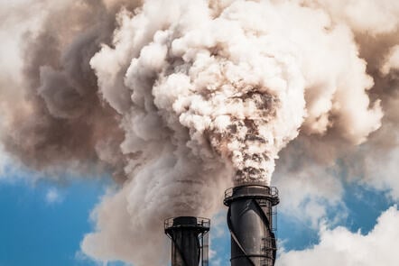 A pair of black factory cooling towers billowing pollution.