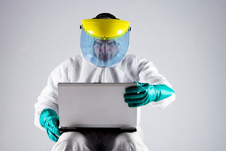 Man in a hazmat suit using a laptop