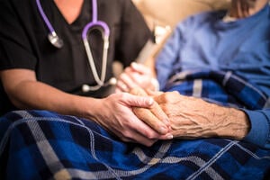 Palliative care - medical practitioner holding hands of patient