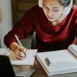 Girl studying at desk with headphones on